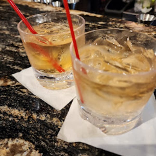 Two cocktails with red straws and ice on white napkins at Da Silva Steakhouse.
